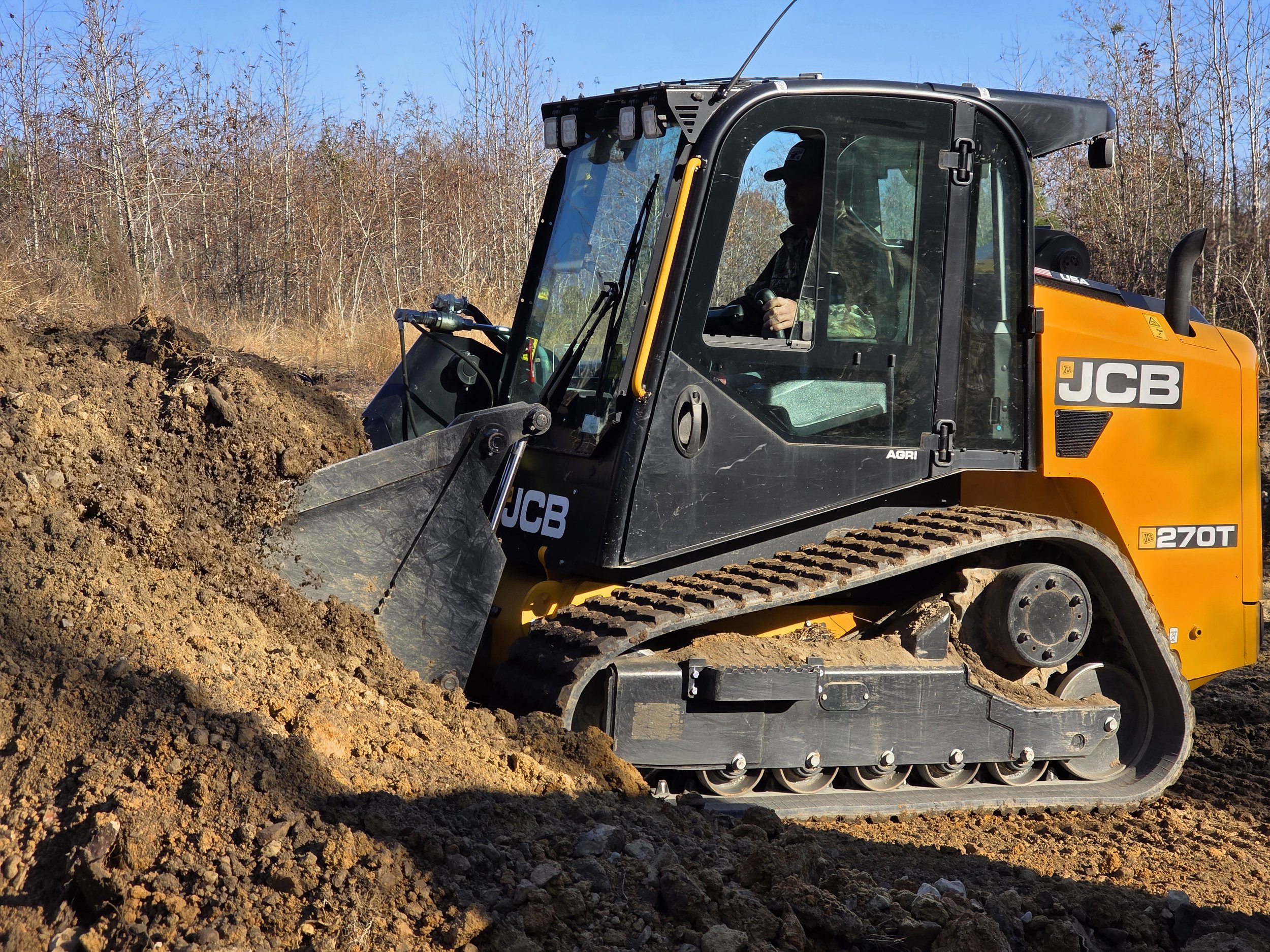 JCB track loader grading soil on a North Carolina job site